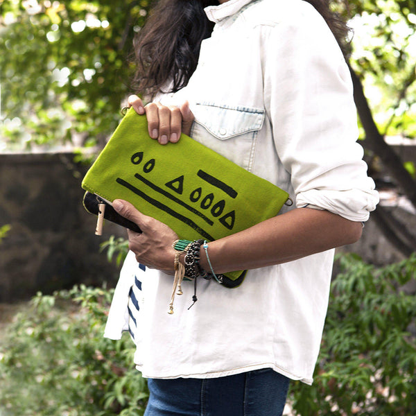 A woman holding a green 'Hazelnut' clutch-Devrim Studio