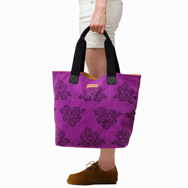 A woman holding a purple urbanite tote bag-Devrim Studio