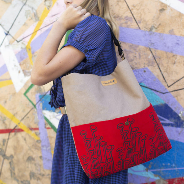 A woman holding a beige and red 'Stuck To The Floor' shoulder bag, crossbody bag - Devrim Studio