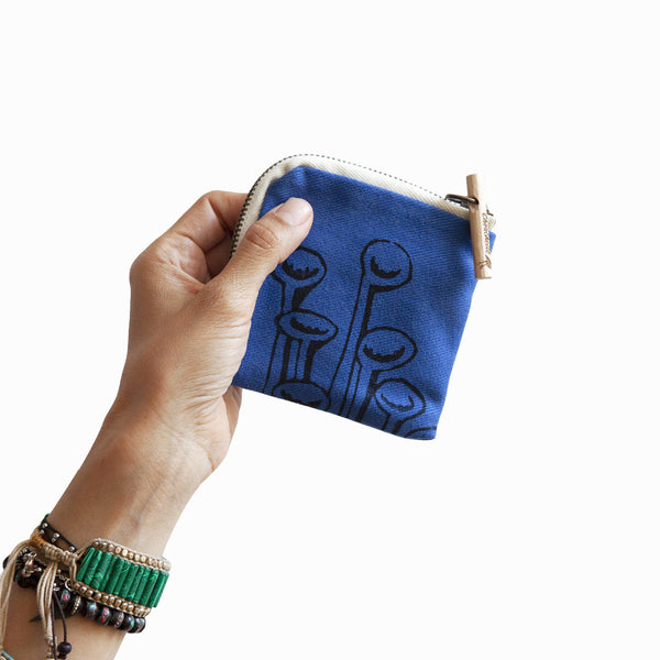 A woman holding a navy blue 'Stuck to the floor' wallet, purse - Devrim Studio
