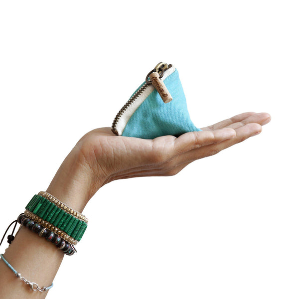A hand holding a turquoise coin purse - Devrim Studio