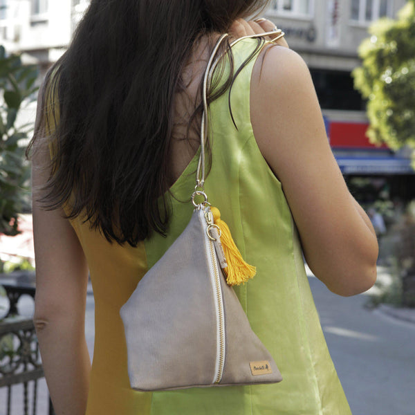 A woman holding a beige Ursula Chain Purse shoulder bag - Devrim Studio