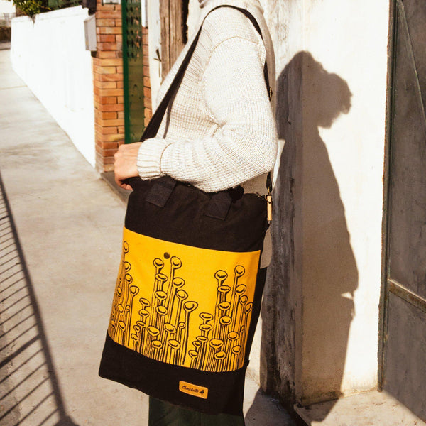 A woman wearing the yellow and black convertible backpack as a shoulder bag - Devrim Studio