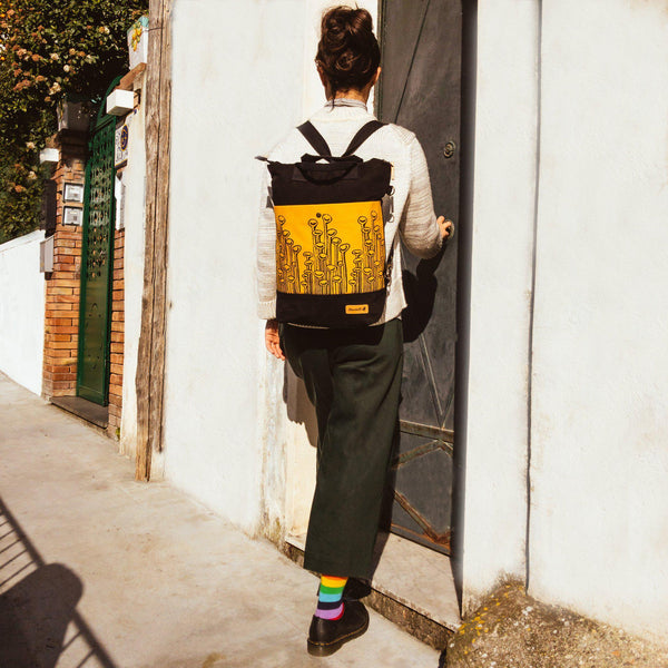 A woman wearing the yellow and black convertible backpack - Devrim Studio